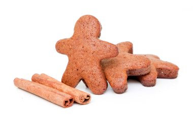 Zencefilli çörekler ve tarçın çubukları beyaz arka planda izole edilmiş.