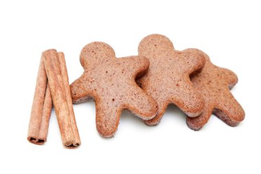 Zencefilli çörekler ve tarçın çubukları beyaz arka planda izole edilmiş.