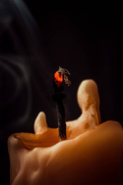 Koyu arkaplanda sarı mum yakın plan.