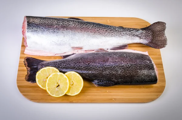 Due pesci trota su piatto di legno — Foto Stock