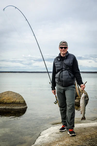 Glücklicher Angler mit Fischertrophäe — Stockfoto