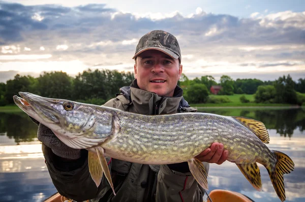 Glücklicher Angler mit riesigem Hecht zur Morgenstunde — Stockfoto