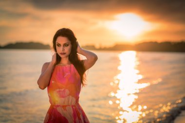 Deniz günbatımı arka plan ile şehvetli esmer 