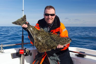 Happy angler with halibut fish