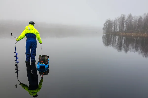 Pescador con equipo de pesca en el hielo — Foto de Stock