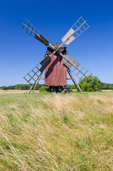 Red wooden windmill on the summer field Royalty Free Stock Images