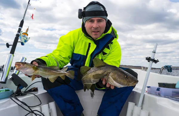 Pescador feliz con dos bacalaos bálticos —  Fotos de Stock