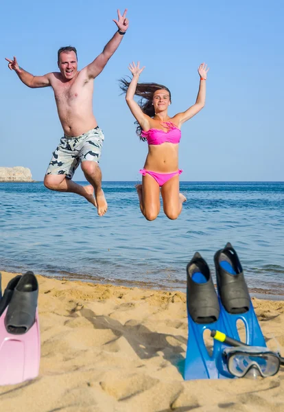 Pai e filha pulando na praia tropical — Fotografia de Stock