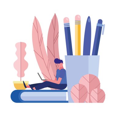 Genç adam defter ve kalem tutacağına oturmuş dizüstü bilgisayar kullanıyor.