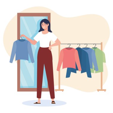 Elbiseleri sallanan yaratıcı genç kadın moda tasarımcısı