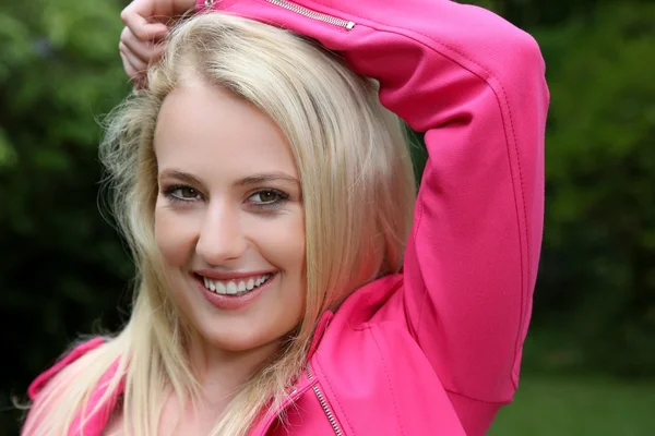 Mooie blonde dame in roze jas — Stockfoto