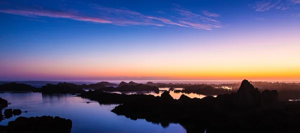 Sonnenuntergang und Felsen an der Küste — Stockfoto