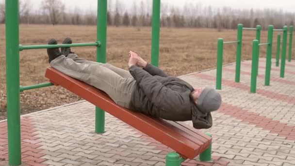 Homem exercitando abdominais no parque — Vídeo de Stock