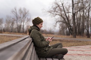 Bir bankta oturan smartphone kadınla