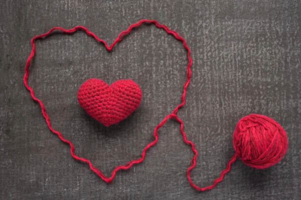 Crocheted red heart on a grunge board — Stock Photo, Image