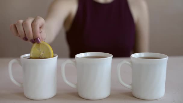 Poner limón en tres tazas de té — Vídeos de Stock