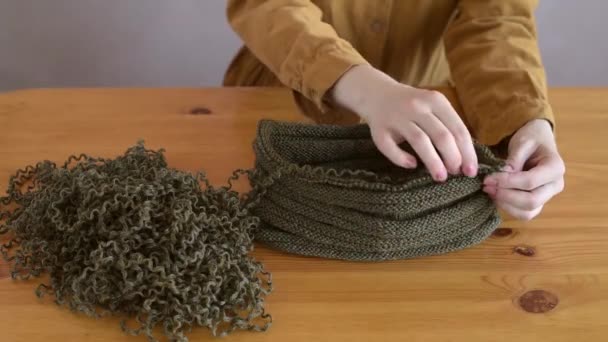 Mujer desentrañando el sombrero de punto — Vídeo de stock