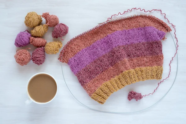 Cup of coffee and knitting on white background — Stock Photo, Image