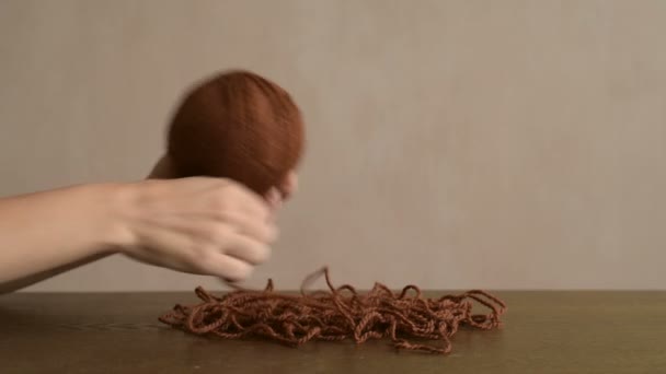 Женские руки прилепляют коричневую пряжу — стоковое видео