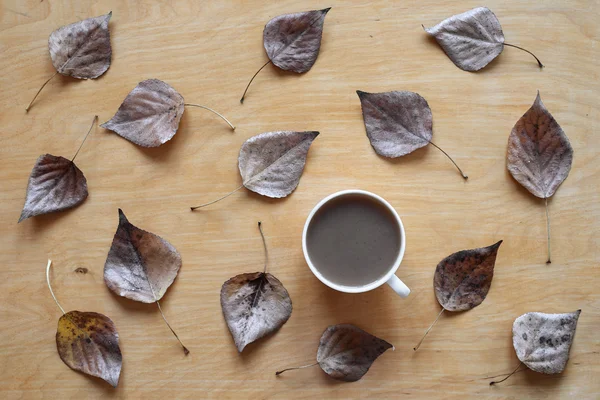 Kaffe och torkade blad på trä bakgrund — Stockfoto