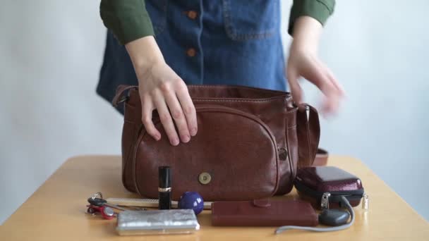 Chica pone sus cosas en una bolsa — Vídeo de stock