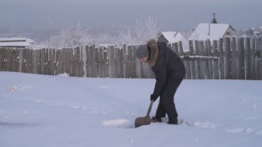 Adam bir kış bahçesinde bir kürek ile kar kazı
