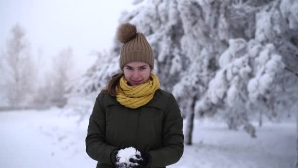 Mulher jogando uma bola de neve na câmera — Vídeo de Stock