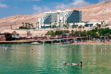 Ölü Deniz'in sahilde turistler.