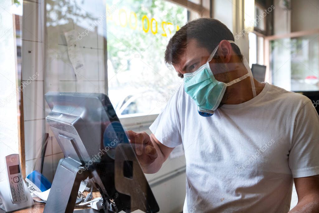 April 24 2020 Lyon, Rhone Alpes Auvergne, France : Man is working in a pizza restaurant drive with his mask and covid 19 protection. Pandemic situation