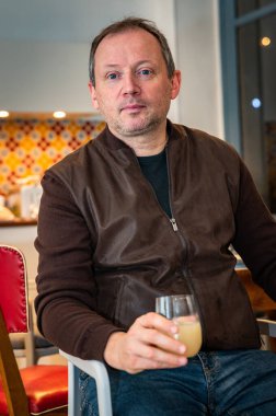 Adam evde rahatlıyor ve bir bardak alkol içiyor.