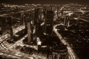 Dubai şehir merkezinde şehir ışıklarıyla dolu bir gece sahnesi.