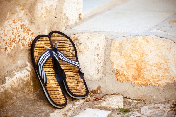 Strand slippers op de oude muur — Stockfoto