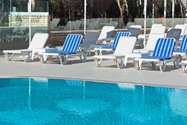 Otel havuz sandalyeleri yakınındaki bir Yüzme Havuzu