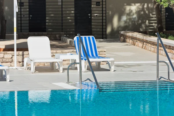 Hotel Sillas junto a la piscina cerca de una piscina — Foto de Stock