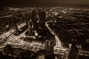 Dubai şehir merkezinde şehir ışıklarıyla dolu bir gece sahnesi.