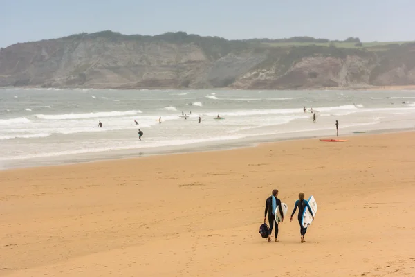 Surfistas caminando juntos hacia el océano — Foto de Stock