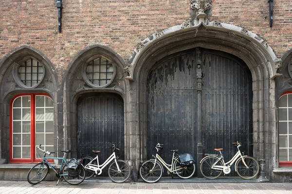 Bicicletas apoyadas en la puerta vieja — Foto de Stock