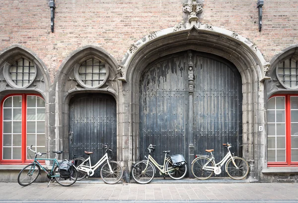 Bicicletas apoyadas en la puerta vieja — Foto de Stock