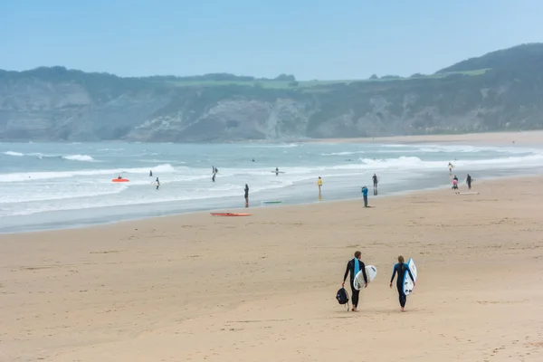 Surfers walking together towards the ocean — Stock Photo, Image