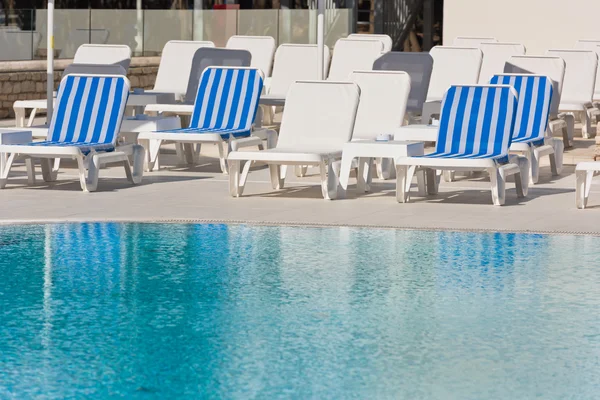 Cadeiras da piscina do hotel perto de uma piscina — Fotografia de Stock