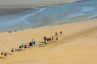 Mont Saint Michel yakınındaki plajda insanlar