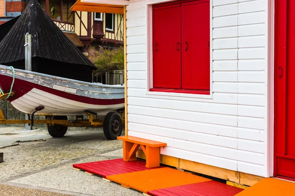 Barco de pesca cerca de casa de madera brillante —  Fotos de Stock