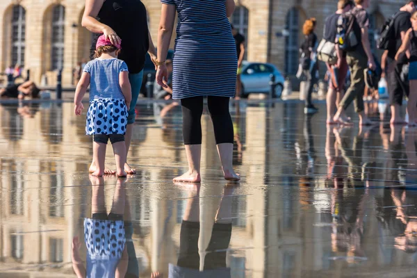 Les gens s'amusent dans une fontaine miroir — Photo