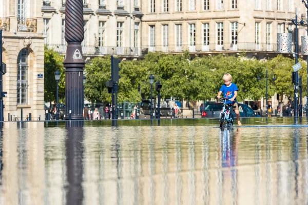 Chico divirtiéndose en la fuente en Burdeos — Foto de Stock