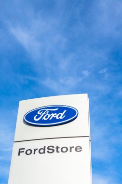 Ford Motor Şirketi 'nin Lyon, Fransa' daki araba satıcısı ofis binasında bulunan parlak mavi gökyüzü arka planının logosu - 23 Şubat 2020