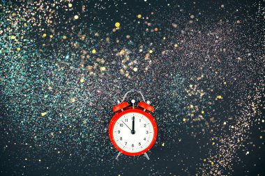 Yeni yıl ya da noel kompozisyonu düz yatıyordu Noel tatili kutlamaları kırmızı alarm saati ve altın konfeti ışıkları siyah arka planda bokeh. Tebrik kartı tasarımı için şablon