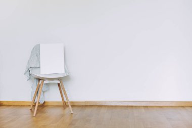 Kapalı bir duvar modeli ya da minimalist tarzda kurumuş çiçeklerle süslenmiş bir poster. Dünyevi Tarafsız Ses Arkaplanı. İçerisi, ahşap zemin ve beyaz duvarlı, havadar ışık tarzında.