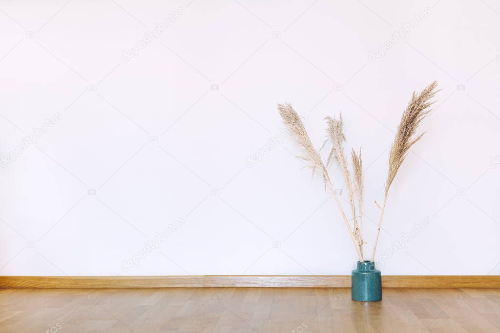 Indoors flat wall mockup with dried Pampas Grass in minimalist style. Earthy Neutrals Tones Background. Interior in airy light style with wooden floor and white wall