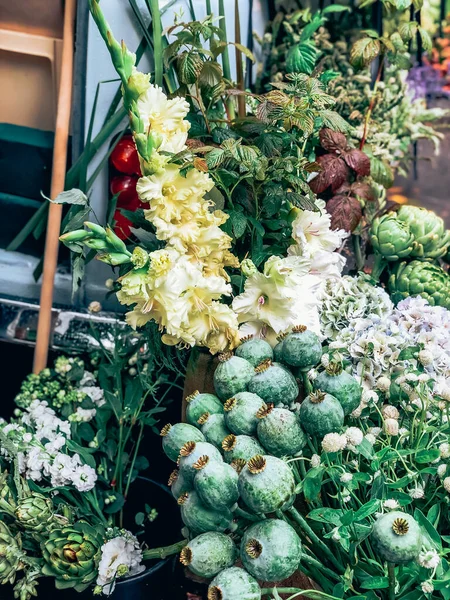 小さな花屋の店で美しい新鮮な装飾的な巨大なポピーの頭や他の花 ライフスタイルの自然光組成物で現代的なスタイルの花配置 小さな仕事だ 携帯写真 ロイヤリティフリーのストック写真