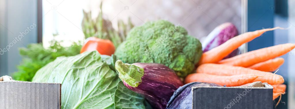 Fresh organic greens and vegetables safe contactless delivery during coronavirus Covid-19 pandemic outbreak. Box with local farmer grocery delivering left in the house doorway. Care package, donation